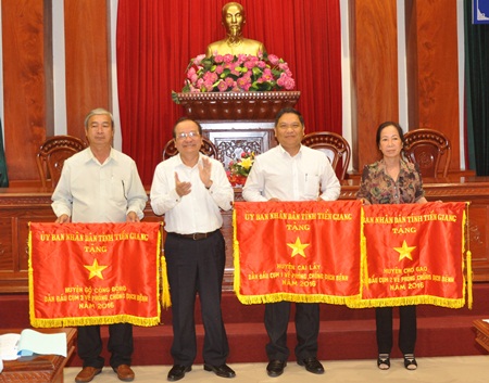 Ông Trần Thanh Đức - Phó Chủ tịch UBND tỉnh Tiền Giang trao cờ thi đua cho 3 đơn vị có thành tích xuất sắc trong công tác phòng chống dịch năm 2016