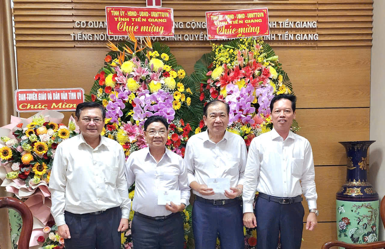 Đồng chí Đỗ Tấn Hùng - Ủy viên Ban Thường vụ, Trưởng Ban Tuyên giáo và Dân vận Tỉnh ủy và đồng chí Nguyễn Thành Diệu, Tỉnh ủy viên, Phó Chủ tịch UBND tỉnh tặng hoa, chúc mừng Báo Ấp Bắc